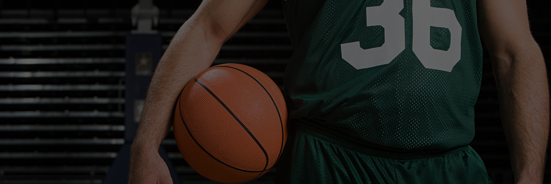 Athlete in green jersey with basketball